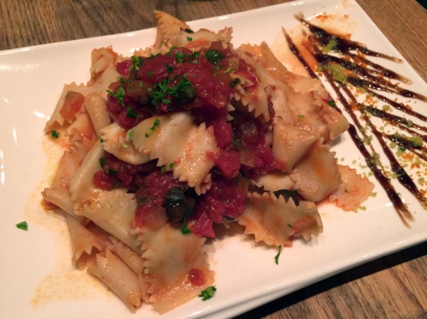 egg pasta with sauce of tomatoes, olives, capers and oregano at in parma